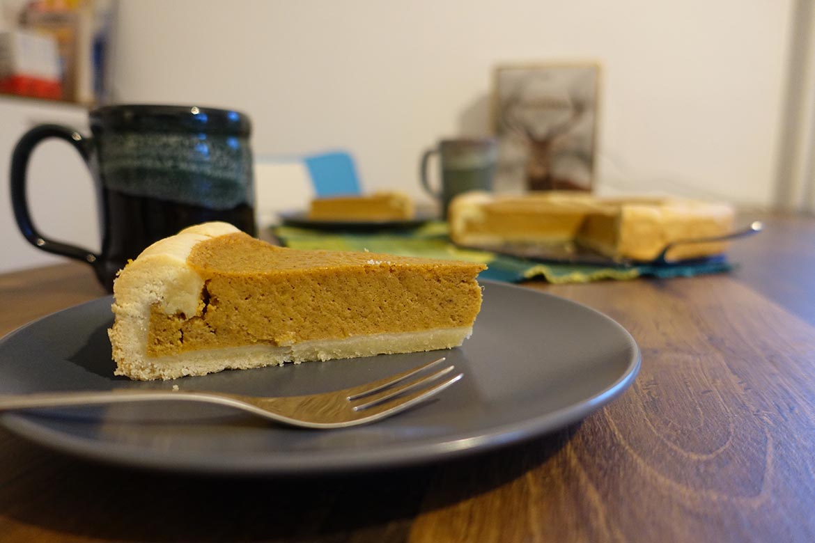 Der Pumpkin Pie ist zu einer Tasse Kaffee auf einem Teller fertig zum Verzehr.