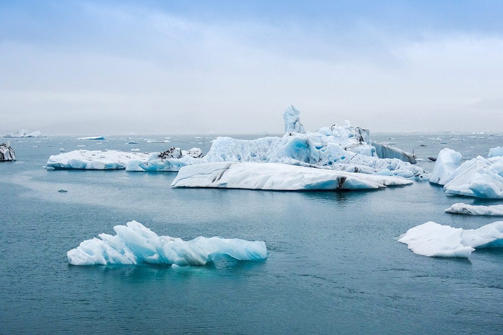 Einige Eisschollen treiben auf dem Meer.