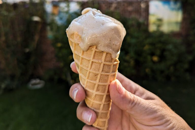 Selbst gemachte Nicecream in der Waffel wird von einer Hand gehalten.