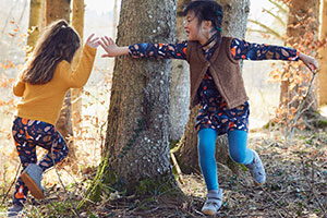 Kinder rennen um einen Baum in bunter Bio-Mode