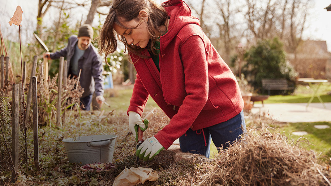 Frau bei herbstlicher Gartenarbeit mit nachhaltigen Gartengeräten