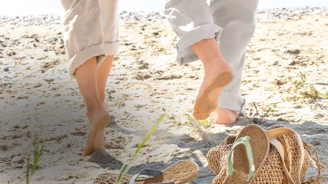 Mann und Frau laufen barfuß durch den Sand
