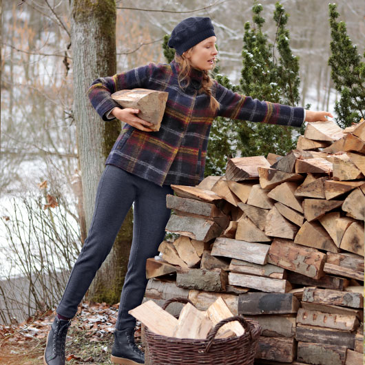 Frau in karierter Walkjacke stapelt Holz