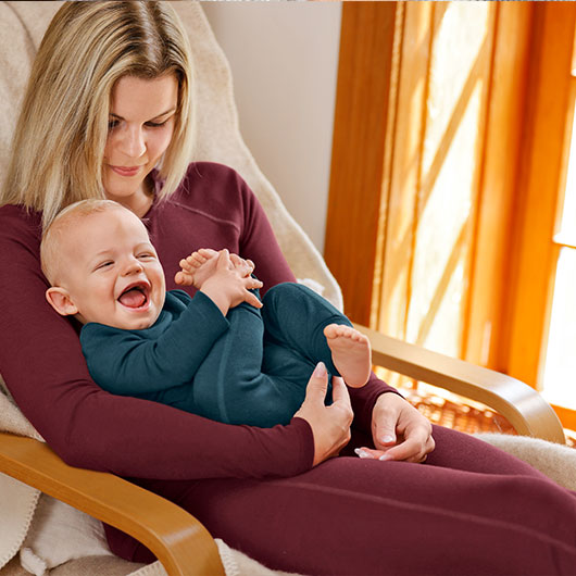 Baby in blauer Leinen-Shorts auf dem Schoß der Mutter