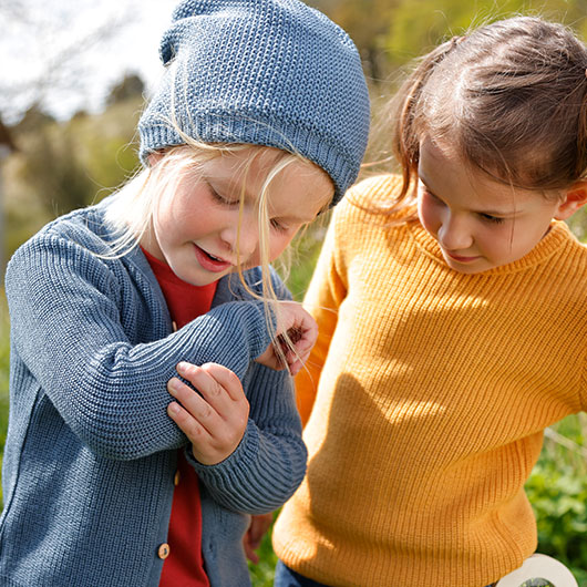 Junge und Mädchen in farbenfrohem und gemütlichem Pullover und Cardigan an der frischen Luft